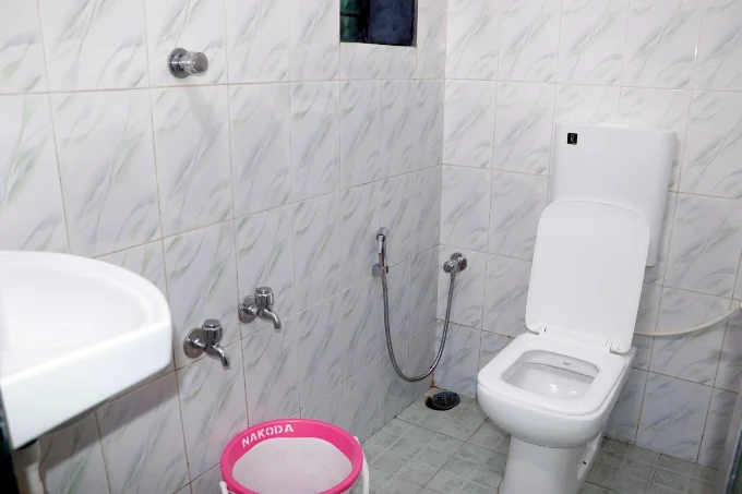Tiled bathroom with toilet and shower fittings