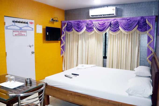 Guest room with bed, air conditioner, television and seating table